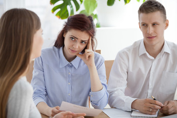 Serious HR managers advisors interviewing young woman student in the office. Employers holding...
