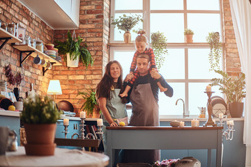 Mom dad and little daughter together in loft style kitchen at morning.