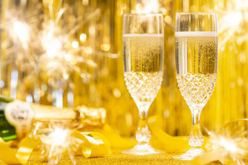 Glasses full of Champagne and  golden glittering background