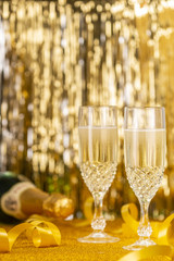 Glasses full of Champagne and  golden glittering background