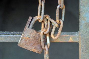 The old lock on the gate in yard-well on rusty chain.