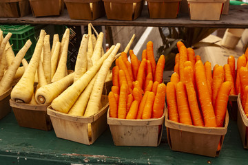 Carrots and parsnips on a market bench