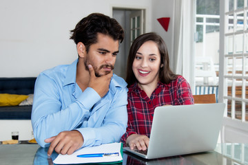 Couple looking online for special offers with computer