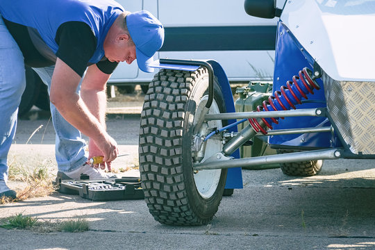 The mechanic serves the car. All-wheel drive off-road racing buggy car