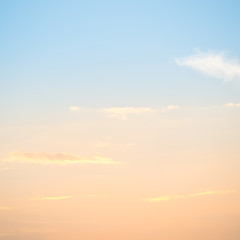 Sunset with sun and clouds on blue and orange pastel sky