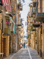 Fototapeta na wymiar A cozy street in Cefalù on a sunny summer day. Sicily, southern Italy.