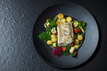 Delicious mediterranean seafood. Fish on a black plate