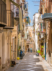 A cozy street in Cefalù on a sunny summer day. Sicily, southern Italy.
