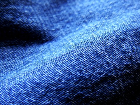 Close up image of vibrant blue textured denim jeans with jeans texture visible