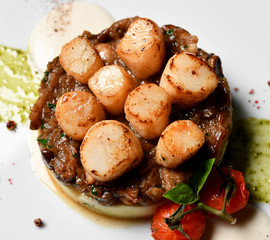 Plate with grilled scallops with butter lemon spicy sauce mashed potatoes and tomatoes