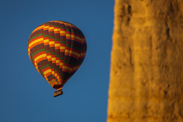 Fototapeta na wymiar Colorful hot air balloon flying over a beatiful blue sky in background
