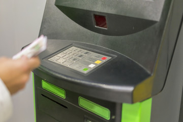 finance, money, bank and people concept - close up of hand with wallet withdrawing cash at atm...