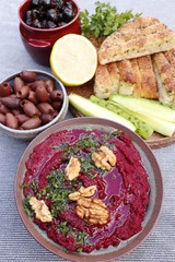 Beet hummus with walnuts, olives, cucumbers and bread.