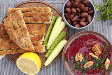 Beet hummus with walnuts, olives, cucumbers and bread.