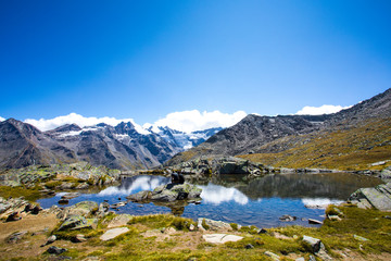 Obraz premium Gran Paradiso Alps mountain - mountain lake with reflections of clouds - Cogne Aosta Valley - Grand Paradis National Park