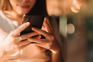 Hand of woman using smartphone on wooden table,Space for text or design.