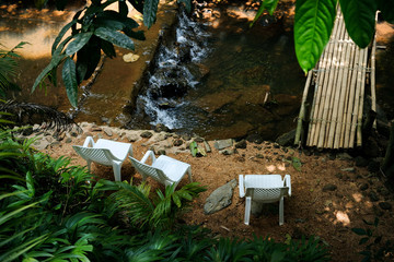 Relaxing chair against waterfalls in forest.