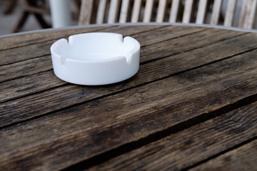White ashtray on a wooden table