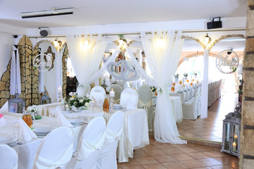 Ślub, wesele, stoły w restauracji nakryte na biało. 