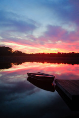 Sunset over lake with boat at pier