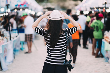Young caucasian woman walking in market on tropical beach.