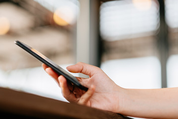 Hand of woman using smart phone in coffee shop.