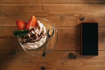 Top view of dessert, strawberry wipe cream on wooden background.