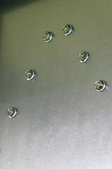 Screw caps on a metal steel wall.
