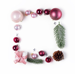 Christmas flat lay frame with pink glass balls and gift box, copy space on white desk