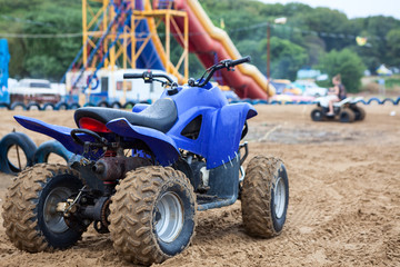 All-terrain vehicle (ATV) is on sandy beach for rent or driving for fun, cross-country tires