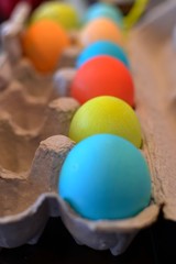 Fototapeta na wymiar Colorful Easter eggs sitting in a carton