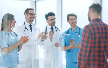 group of doctors congratulating the patient on his recovery