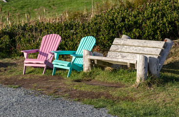 wooden bench in the park, colourful chairs, path.