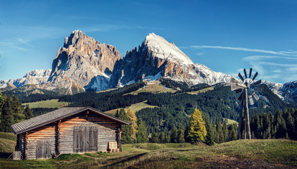 Fototapeta na wymiar Hut with Alpe di Siusi - Seiser Alm with Sassolungo - Langkofel and Plattkofel mountains in background