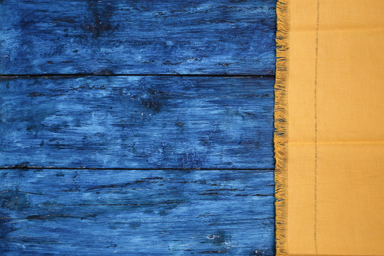 Yellow napkin from right side of dark blue painted board