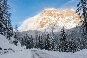 Icy Mountain Road Through a Snowy Mountain Landscape in the Alps and Blue Sky