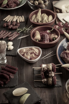 Tapas appetizers on wooden table. Vintage effect