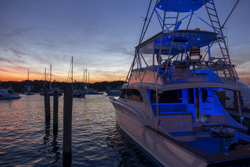 Multilevel motor boat with sunrise sunset sky dark reflections water blue vacation recreational parked at harbor