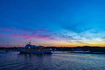 Obraz premium Multilevel motor boat with sunrise sunset sky dark reflections water blue vacation recreational passenger travels harbor