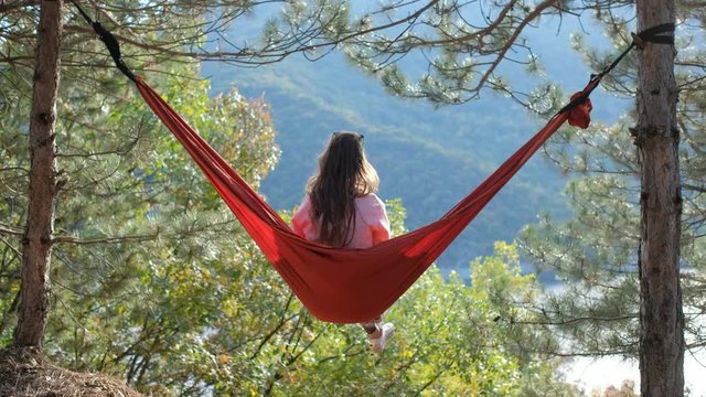 Young woman in hammock near lake