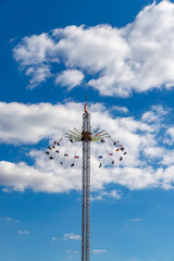 Obraz premium Very large chain carousel in front of blue sky with white clouds. Worms, 