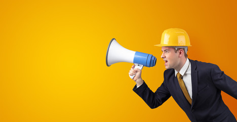 Fototapeta premium Young architect constructor yelling with megaphone and copyspace