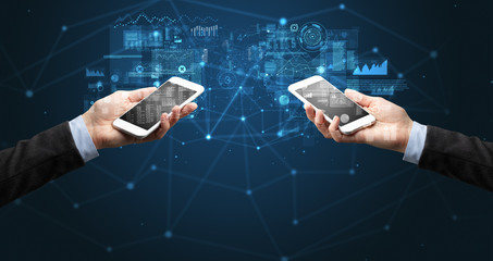 Close up of two hands holding smartphones to sync business data
