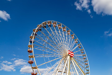 Ferris wheel on a fairground in front of a blue sky