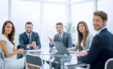 group of business people sitting at a table in the office