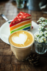 The hot latte art coffee with Colorful cake in coffee shop