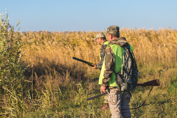 Hunters with a german drathaar and spaniel, pigeon hunting with dogs in reflective vests	