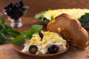 Beautiful appetizer of eggs with crab meat, pickled olives, basil  leaves, toasted toast.