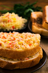 Double sandwich with crab meat and grated cheese.
