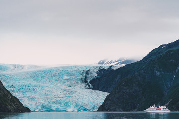 View of Holgate Glacier in Kenai Fjords National Park - unidentifiable ship sails close to the glacier